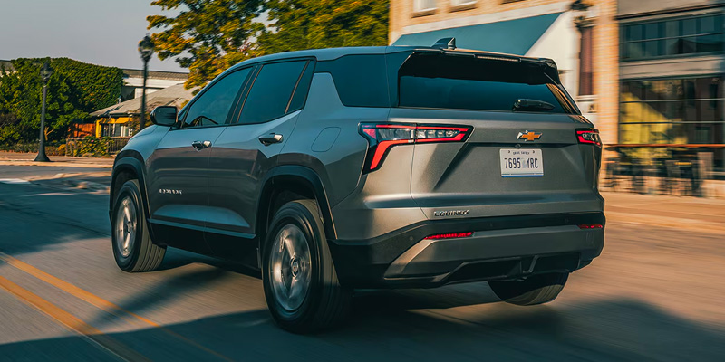 Gray Chevrolet Equinox SUV driving on a city street.
